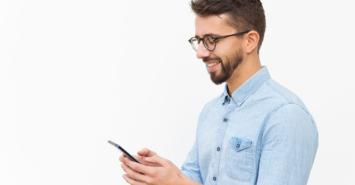 Image of a man dialing on a cell phone.